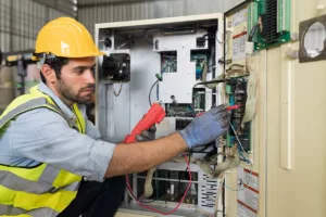 An electrician investigates a control panel during a commercial electrical inspection.