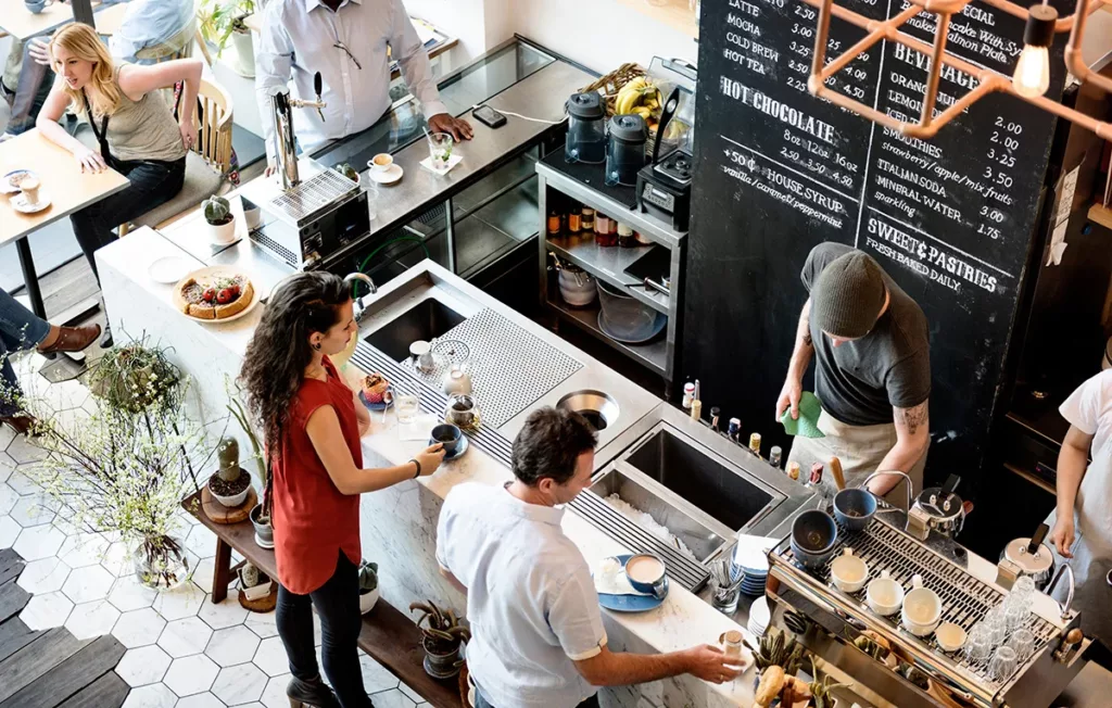 Customers shop at a busy cafe while waiting for their EV to charge.