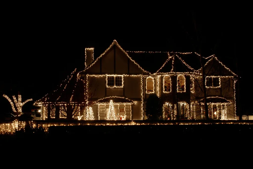 The exterior of a house decorated with holiday lights, showing the concept of electrical safety tips for the holiday season.