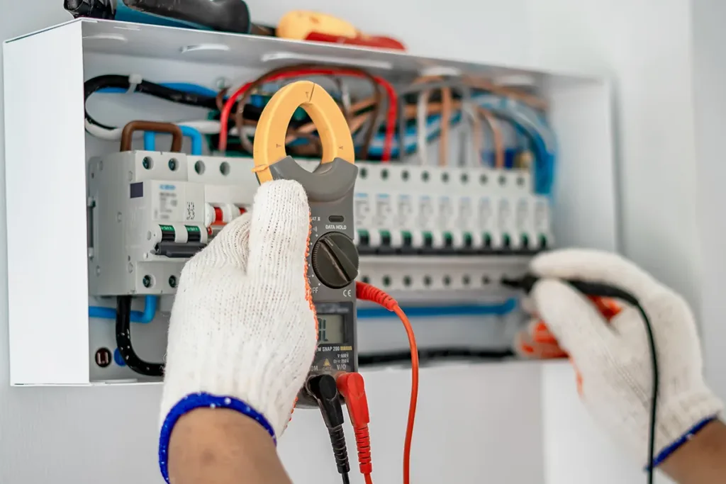 A close-up shot of an electrician fixing an outdated electrical control panel